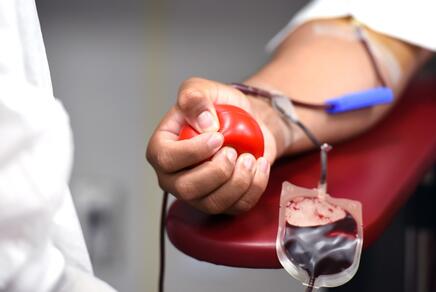 Hand eines Blutspenders und Blutbeutel