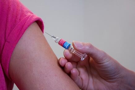 Eine Persond wird am Oberarm mit einer Spritze geimpft.
